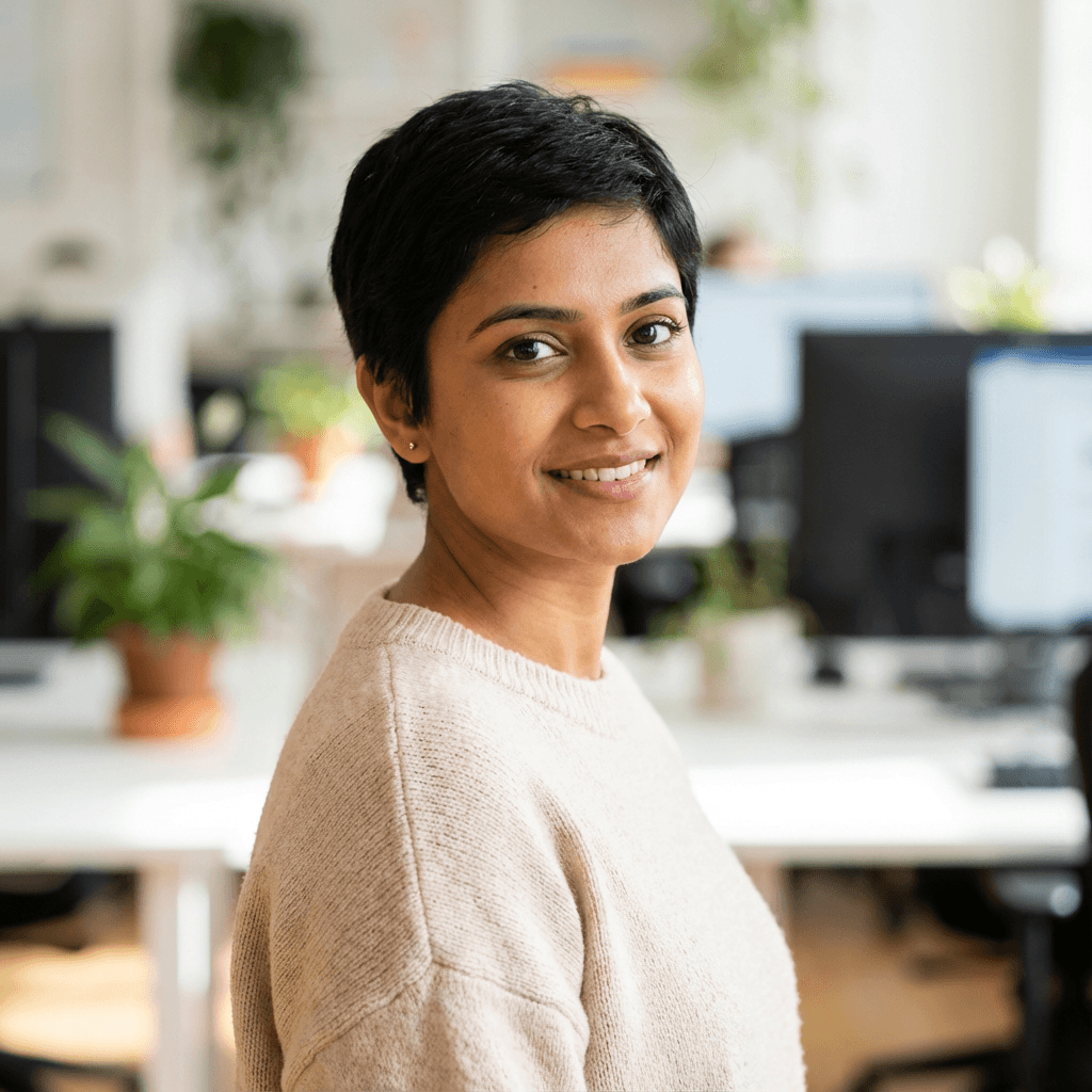 Indian female digital strategist in her late 20s working on a laptop in a bright office